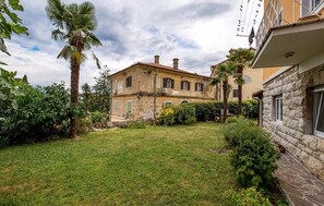 Experience a tranquil retreat in a beautifully maintained garden surrounded by lush plants and a majestic palm tree.