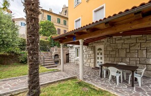 Experience the perfect blend of history and comfort in this charming stone building, featuring a patio area with outdoor dining space and a tranquil atmosphere.