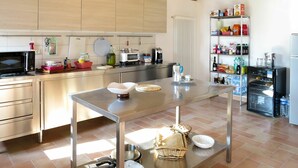 Uma cozinha moderna com eletrodomésticos de aço inoxidável, uma ilha central e frigorífico embutido.