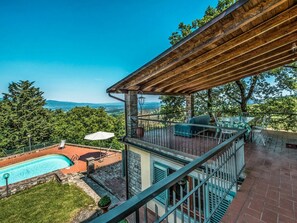 Eine Dachterrasse mit Pool, Sitzgelegenheiten im Freien und Blick auf die Landschaft.