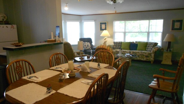 A dining area with a wooden table and chairs, a chandelier, and a ceiling fan. - Quiet 3 bedroom, 2 Bath Home located within 1/2 mile of ferry to Cape Lookout  (Harkers Island)