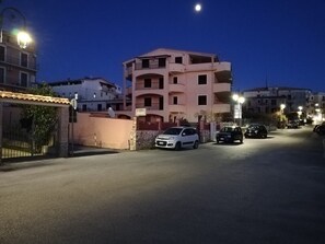 A multi-story building with balconies, a gated entrance, and parked cars. - Panoramic Apartment with two bedrooms  (Marina di Camerota SA)
