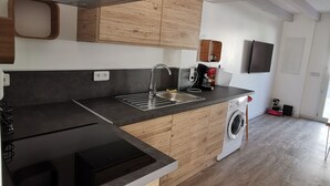 A modern kitchen with wooden cabinets, a stainless steel sink, and a built-in washing machine. - Duplex T3 Anglet - Parking / Terrace / Pool - (Anglet)