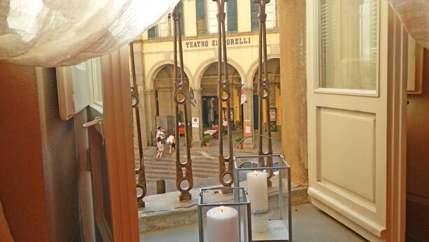 A corridor with a view of a building labeled "TEATRO S. IORELLI".