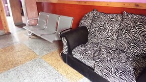 Un espace d’attente avec un canapé à motifs zébrés et une chaise en métal.
