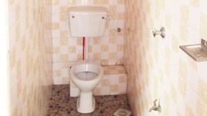 Une petite salle de bain avec des toilettes, un lavabo et une douche.