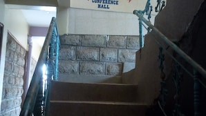 A staircase with a sign indicating an 'UP-STAIR CASE' leading to 'OFFICES' and 'CONFERENCE HALL'.