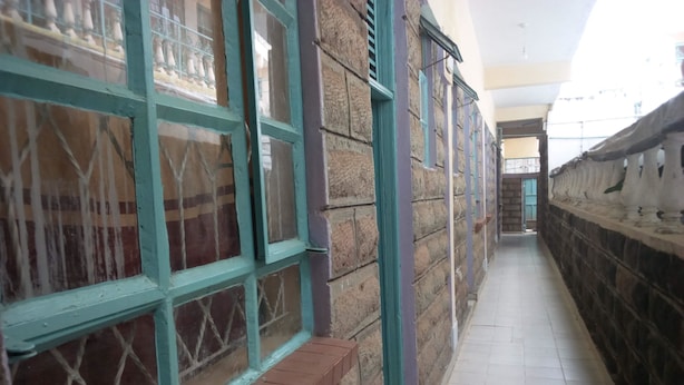 A corridor with stone walls and a tiled floor.