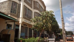 A multi-story building with a sign reading "GUEST HOUSE" and "JOYLAND VILLA".