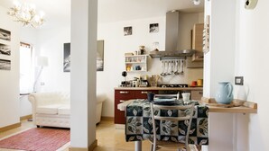 Un espacio habitable compacto con comedor, kitchenette y sofá en la sala.