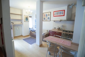 Cocina moderna con comedor, piso de madera y radiador.