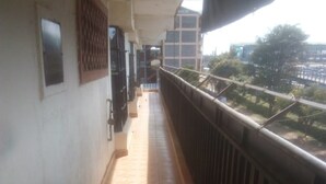 A corridor with tiled flooring and a metal railing on one side. - Juja Modern guest house (Juja)
