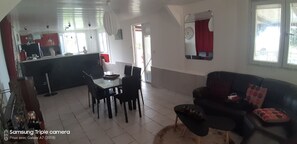 Relax in this spacious living area with a dining table for four, a comfortable sofa, and a kitchenette.