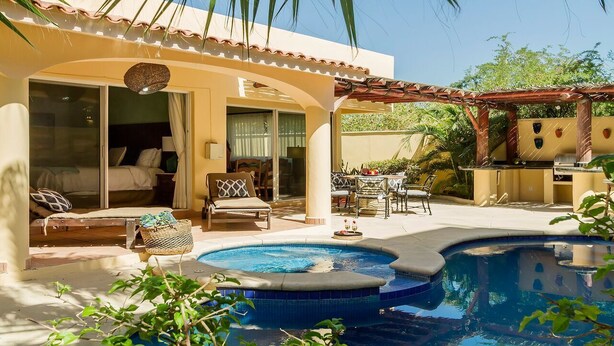 A pool area with a hot tub, outdoor seating, and a bedroom with a sliding glass door. - CASA ESPERANZA in Pedregal, Cabo San Lucas (Pedregal)