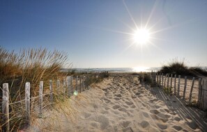 A sandy beach path with wooden fencing and grass on either side, leading to the ocean. - Beautiful home in Saint-André (Saint-André)