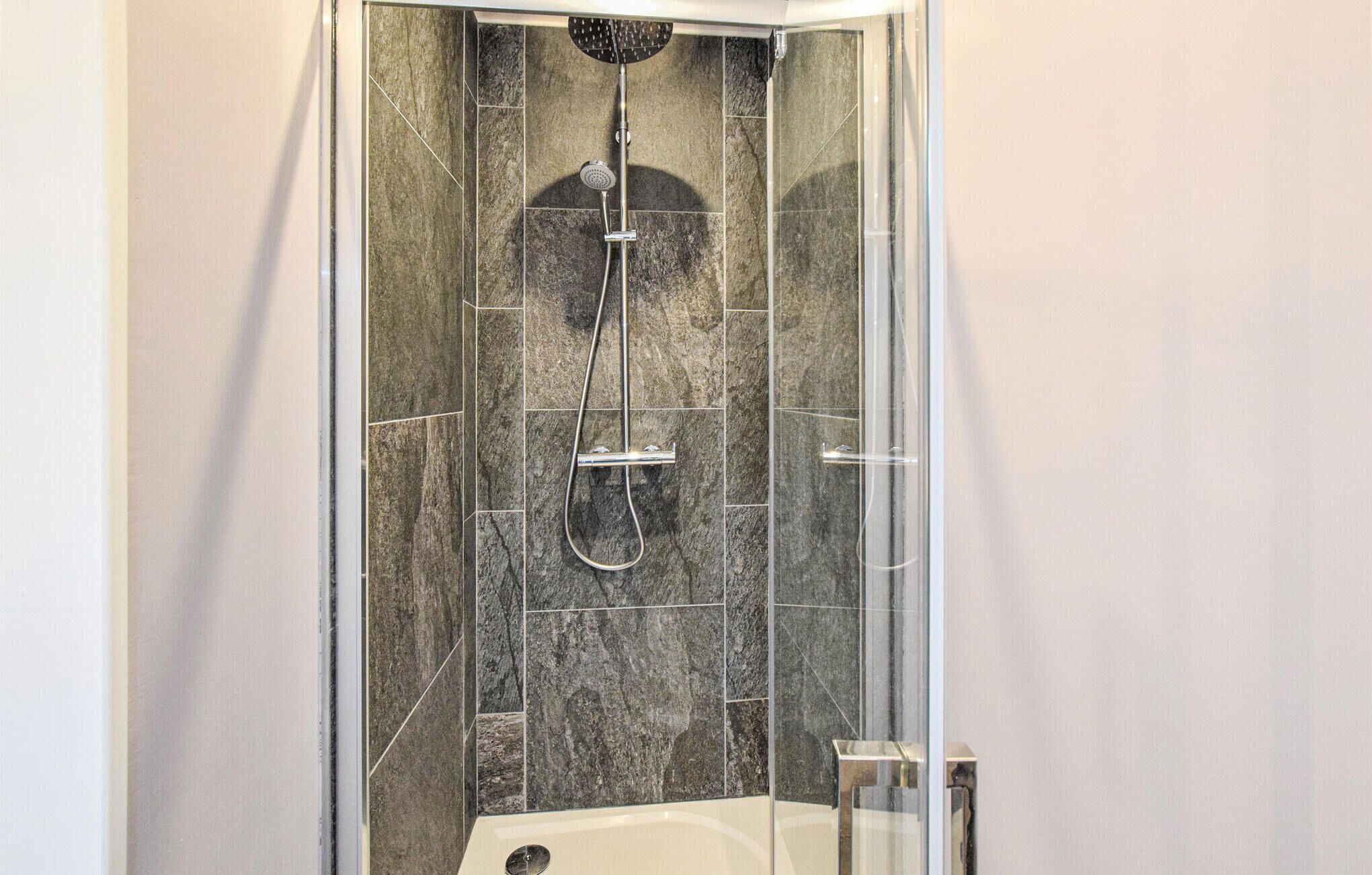 Eine Dusche mit Regendusche, Duschbrause und Handbrause.