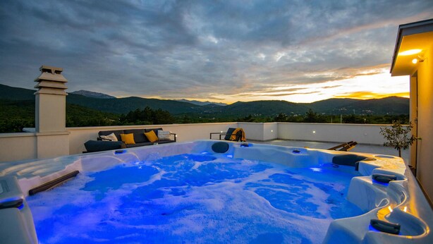 A hot tub with a mountain view, a sofa, and a chair on a rooftop. - Lovely home in Poljica with sauna (Poljica)