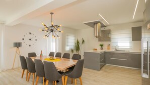 A modern kitchen with a central island, grey cabinets, and stainless steel appliances. - Lovely home in Poljica with sauna (Poljica)
