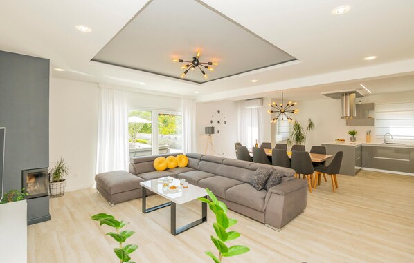 A modern living room with a sectional sofa, a coffee table, and a dining area with a table and chairs. - Lovely home in Poljica with sauna (Poljica)