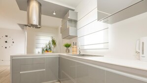 A modern kitchen with grey cabinetry, a stainless steel range hood, and a Bosch coffee machine. - Lovely home in Poljica with sauna (Poljica)