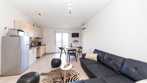 Un appartement moderne comprenant une cuisine, un coin repas et un salon.