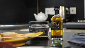 A kitchen counter with a jar of honey mustard, a bottle of mustard, and a teapot. - Lovely, Light and Airy 1-bed Flat in Stornoway (Stornoway)