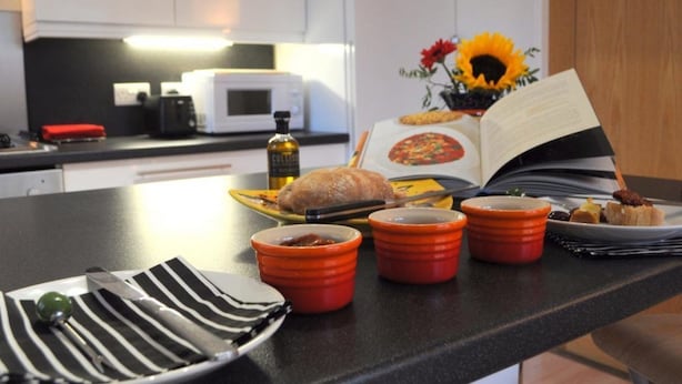 A kitchen counter with a loaf of bread, a book, and a vase with sunflowers. - Lovely, Light and Airy 1-bed Flat in Stornoway (Stornoway)