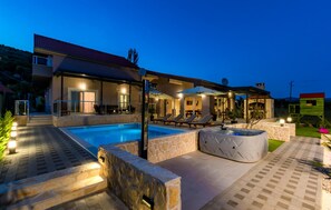 A modern house with a swimming pool, outdoor seating, and a stone patio. - Lovely home in Siveric with sauna (Siveric)