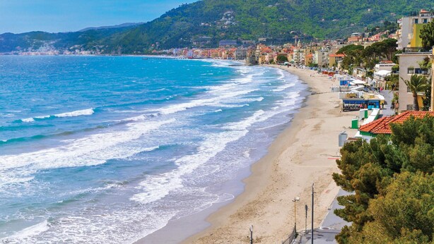 A coastal town with a beach, buildings along the shore, and a hilly backdrop. - Amazing apartment in Pietra Ligure with WiFi (Pietra Ligure)