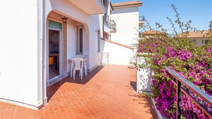 A balcony with a tiled floor, white chairs, and a table. - Amazing apartment in Pietra Ligure with WiFi (Pietra Ligure)