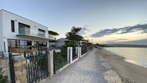 A modern house with a gravel pathway leading to the beach. - Villa Récampado - Feet in the water, pool and sea (Cavalaire-sur-Mer)