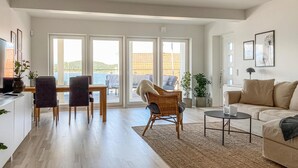 A spacious living area with a dining table, two chairs, a sofa, and a coffee table. - Cozy apartment in Svanesund with WiFi (Svanesund)