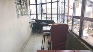Una habitación con un ventanal grande, una mesa de madera y una silla.