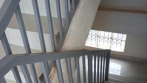 Una escalera con barandillas de metal y un ventanal en la parte superior.