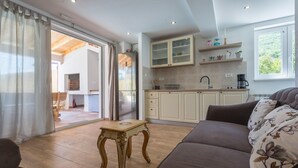 Una cocina moderna con gabinetes blancos, cafetera y ventana con vista a zonas verdes.