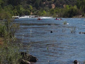 A river with kayaks and a rocky shoreline. - Gorgeous Riverfront Home, VHR# 073569, TOT# T65183 (Lotus)