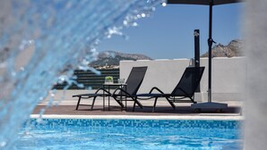 A poolside area with lounge chairs and a table, a clear view of the mountains in the background, and a tiled pool edge. - Luxurious home in Split (Split)