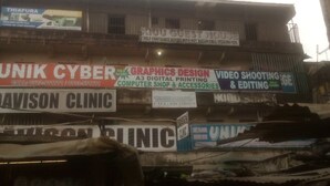 A multi-story building with various business signs, including a guest house, cyber cafe, and clinic. - Kiuu Guest House (Ruiru)