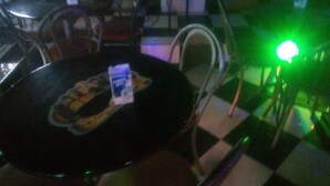 Une table sur laquelle se trouvent un disque vinyle et une petite boîte, le tout entouré de chaises.