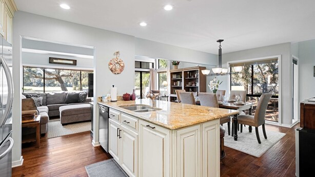 A spacious kitchen with a large island, a dining area with a table and chairs, and a living area with a sofa and a coffee table. - Daze Off! Stunning end unit villa  with two bedrooms and loft. Two King Beds! (Hilton Head Island)