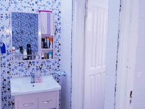 Une salle de bain équipée d’un lavabo, d’un miroir et d’articles de toilette.