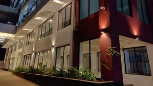 Un edificio de varios pisos con grandes ventanales y fachada roja.