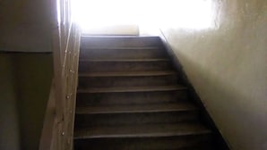 Una escalera de madera con barandilla que lleva a una plataforma.