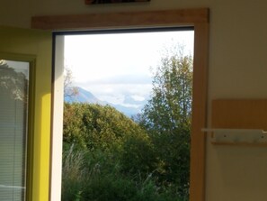 Enjoy breathtaking views of the surrounding landscape from the large window in this serene room.