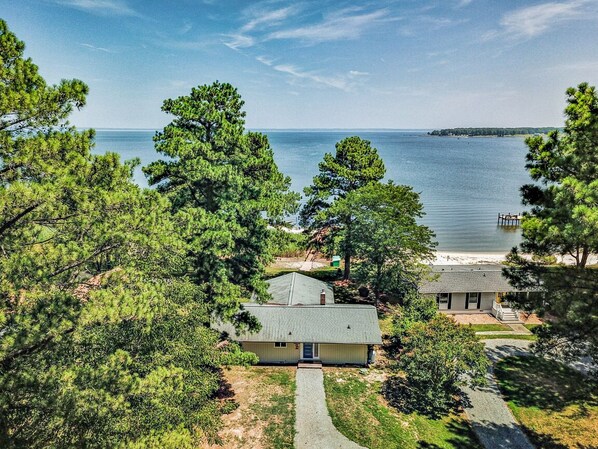 Enjoy serene lakeside living with a porch, lush surroundings, and a dock perfect for water activities.