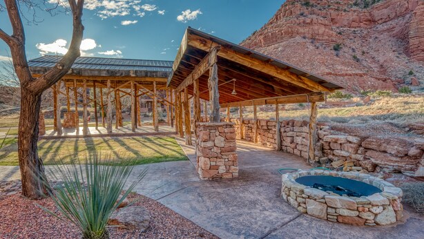 A covered outdoor area with stone walls and a fire pit.