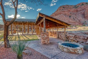 A covered outdoor area with stone walls and a fire pit.
