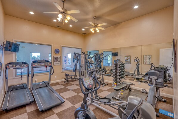 A gym with treadmills, elliptical machines, and free weights.