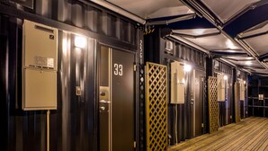 A corridor with doors numbered 33 and 34, a wooden floor, and a metal fence. - Hotel R9 The Yard Oyamakizawa (Oyama)