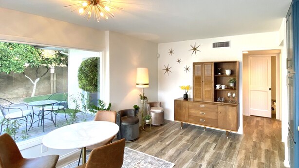 A modern kitchen with a round dining table, two chairs, a cabinet, and a ceiling light fixture. - The Litchfield Park Place w/ Heated Pool near Wigwam Golf Resort & State Farm (Litchfield Park)